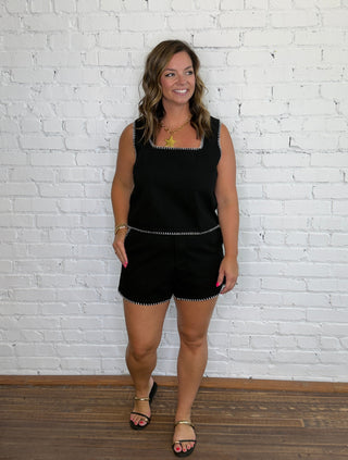 A woman wearing a black with white trim matching set.