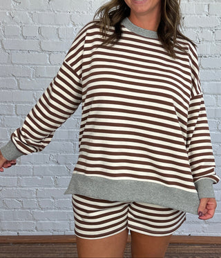 Women wearing a casual chocolate brown and cream striped matching set with a gray hem.