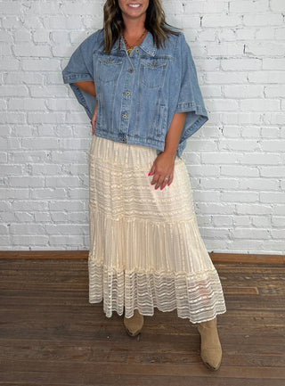 Denim jacket and a long cream lace, pleated midi skirt.