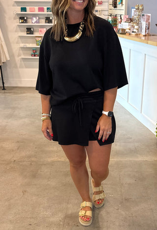 Woman in a black matching skort outfit