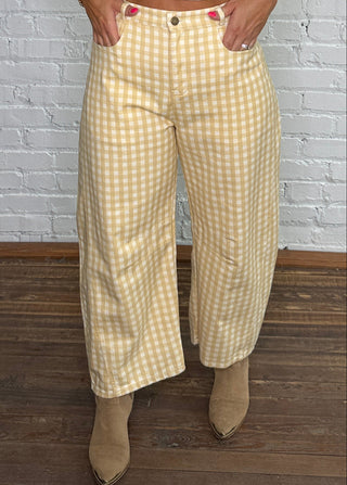 Cream knit sweater and yellow-and-white gingham barrel jeans with tan ankle boots.