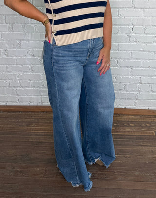 Navy and beige horizontal striped top,  paired with wide-leg blue jeans.
