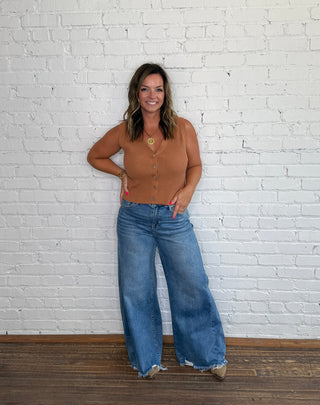 Fitted tan button-front top and wide-leg blue jeans