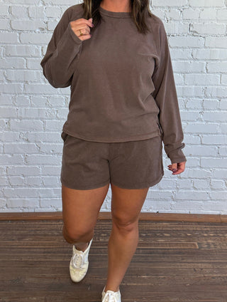 Women wearing a casual brown matching set with butter yellow tennis shoes.