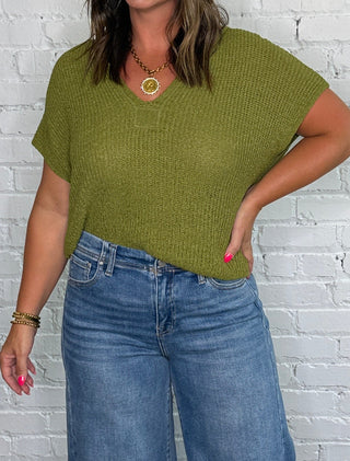Olive green short-sleeve top and wide-leg blue jeans.