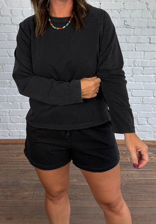 Women wearing a casual matching black set with colorful necklace.