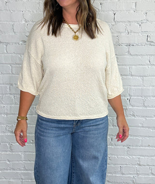 Cream short-sleeve top and blue jeans.