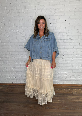 Denim poncho and a cream pleated lace skirt paired with boots.