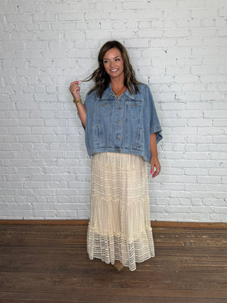 Denim poncho and a midi cream tiered skirt.