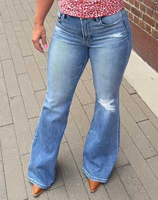 Red floral top and blue jeans paired with mules.