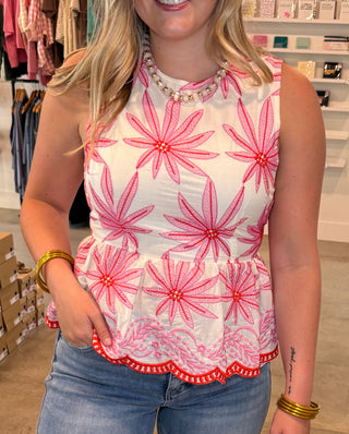 Woman wearing a pink floral top and blue jeans 