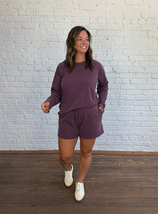 Women wearing a plum casual matching set paired with butter yellow tennis shoes.