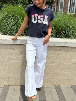Navy 'USA' t-shirt paired with white denim jeans