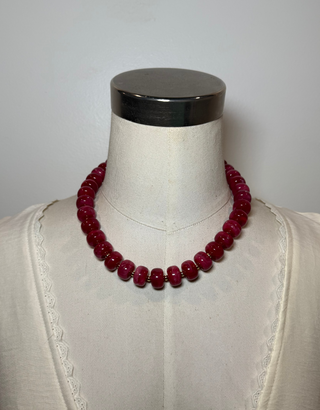 A dark red beaded necklace.