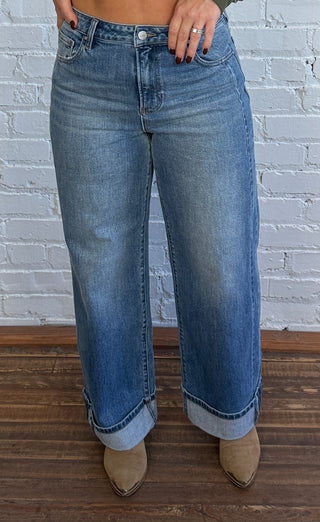 Women wearing medium wash cuffed jean and boots.